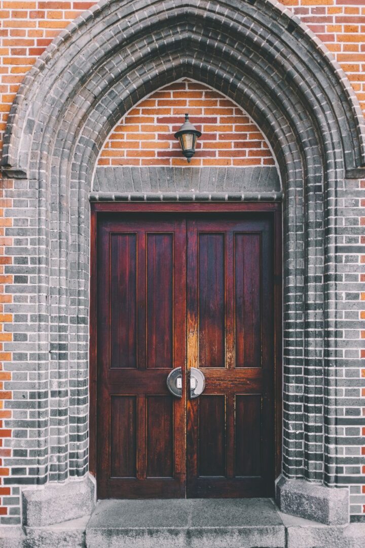 A door with two wooden doors and one is closed.